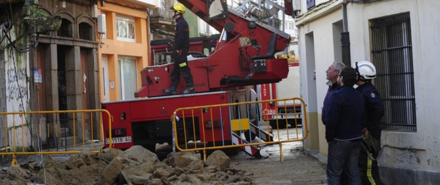 La caída de una pared medianera destroza un coche en Ferrol Vello