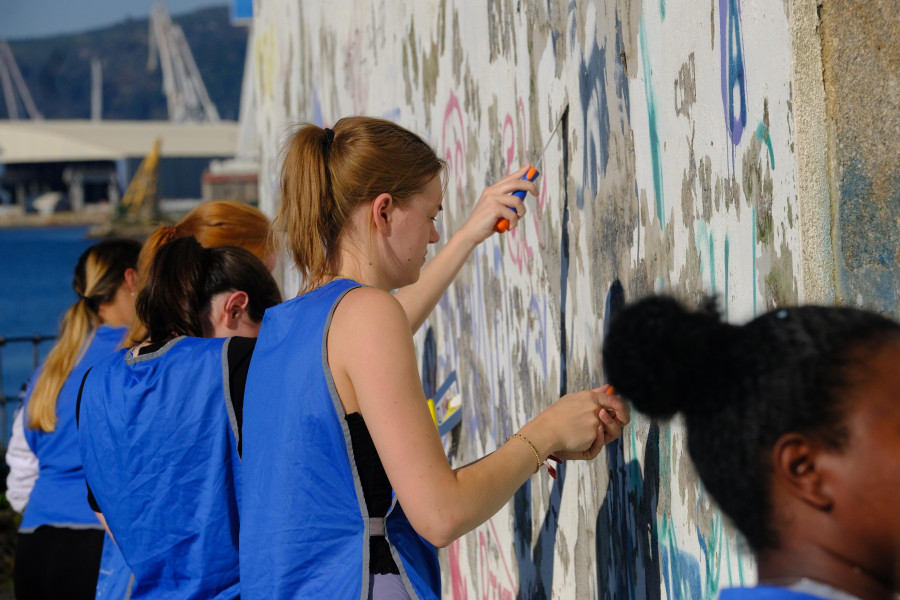 Un grupo de voluntarios limpian las paredes de la ermita del paseo de Caranza