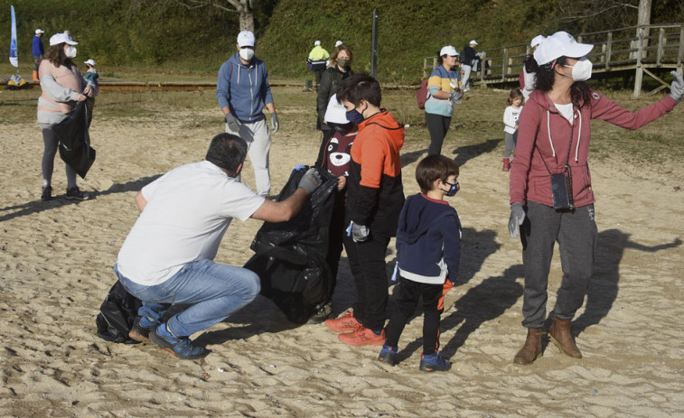 Medio cento de persoas retiran plásticos e madeira da area da praia de Caranza