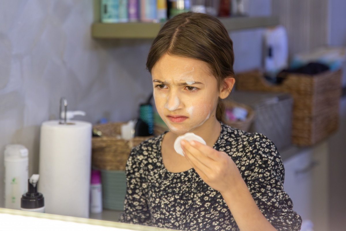 Una chica se seca el cabello con un secador de cabello en el concepto de higiene del bano