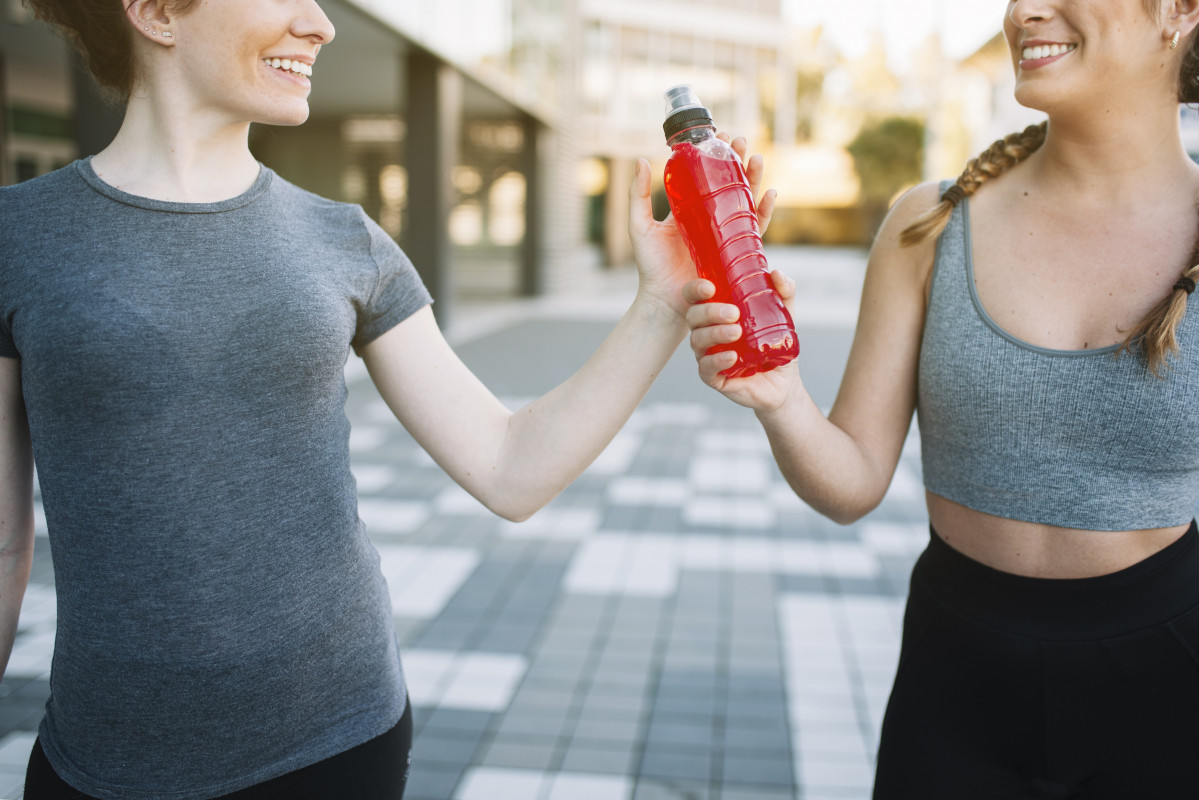 Cosecha mujeres en forma alegre con bebida roja