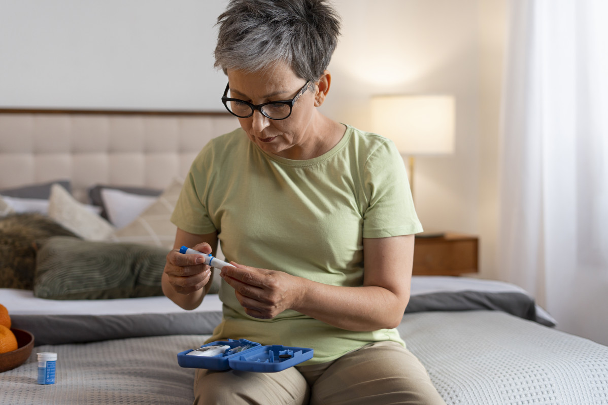 Mujer diabetica de tiro medio comprobando su nivel de glucosa