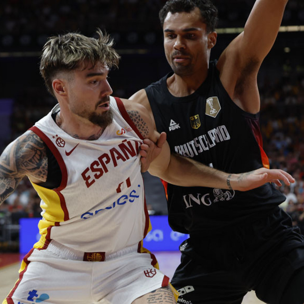 El ala pívot de la selección española de baloncesto Juancho Hernangómez (i) juega un balón ante un jugador alemán, durante el pa
